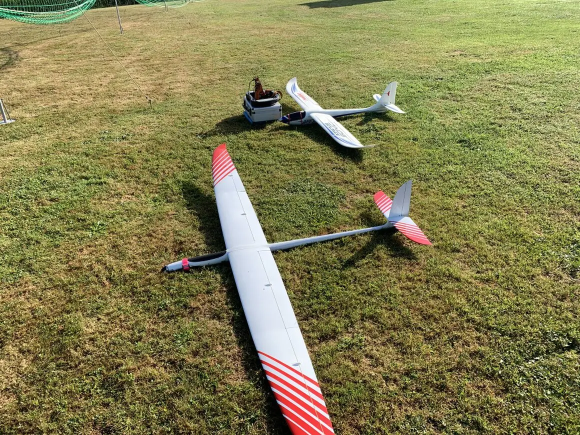 RC Segelflugmodelle und Piloten am Hang mit weiter Landschaft im Hintergrund